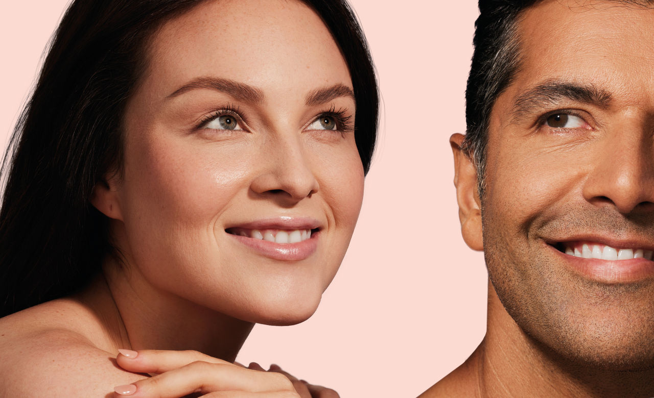 a man and a woman looking out and smiling